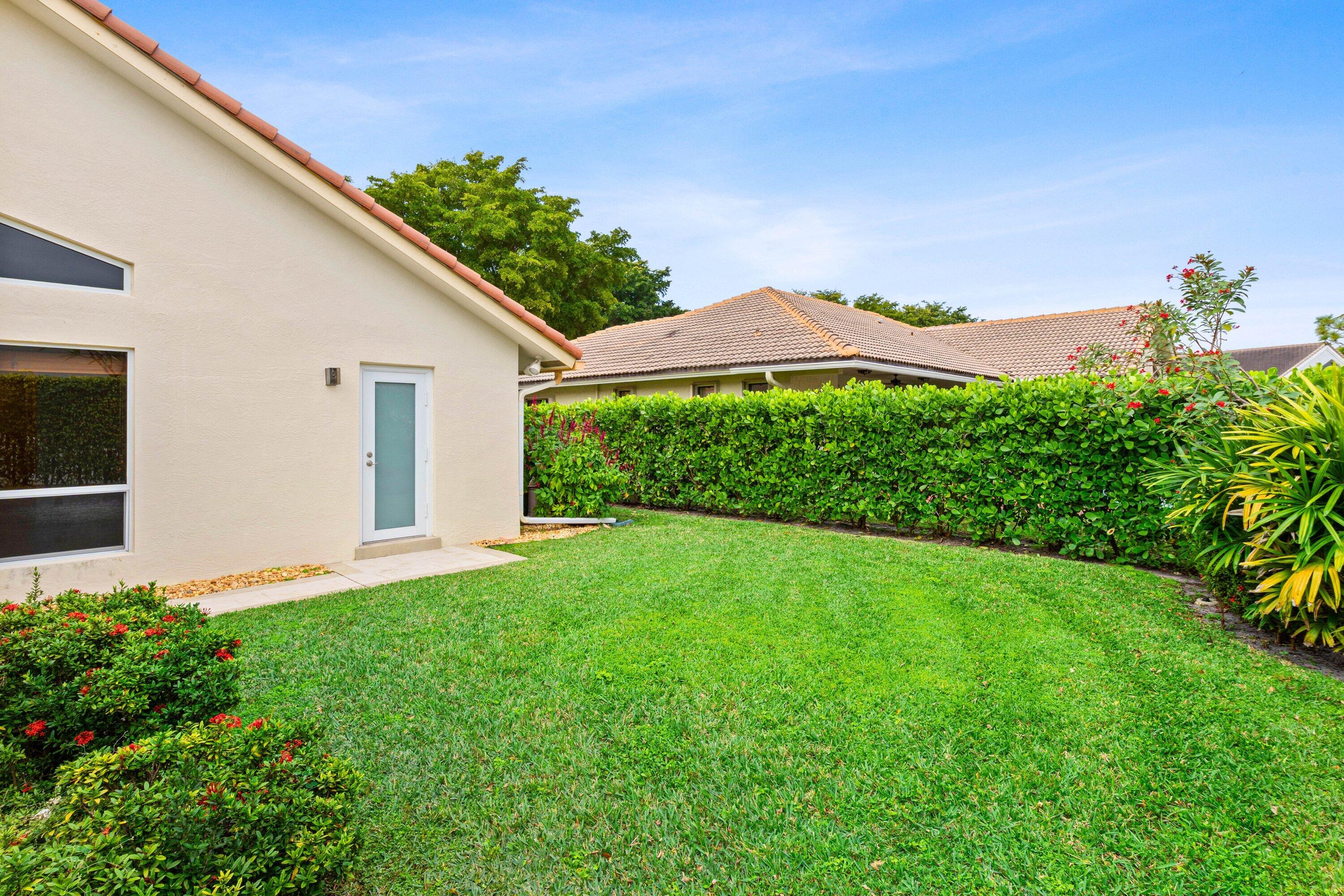 4720 Northwest 28th Avenue Boca Raton, FL 33434 - Photo 31 of 47 a view of a house with a yard and potted plants