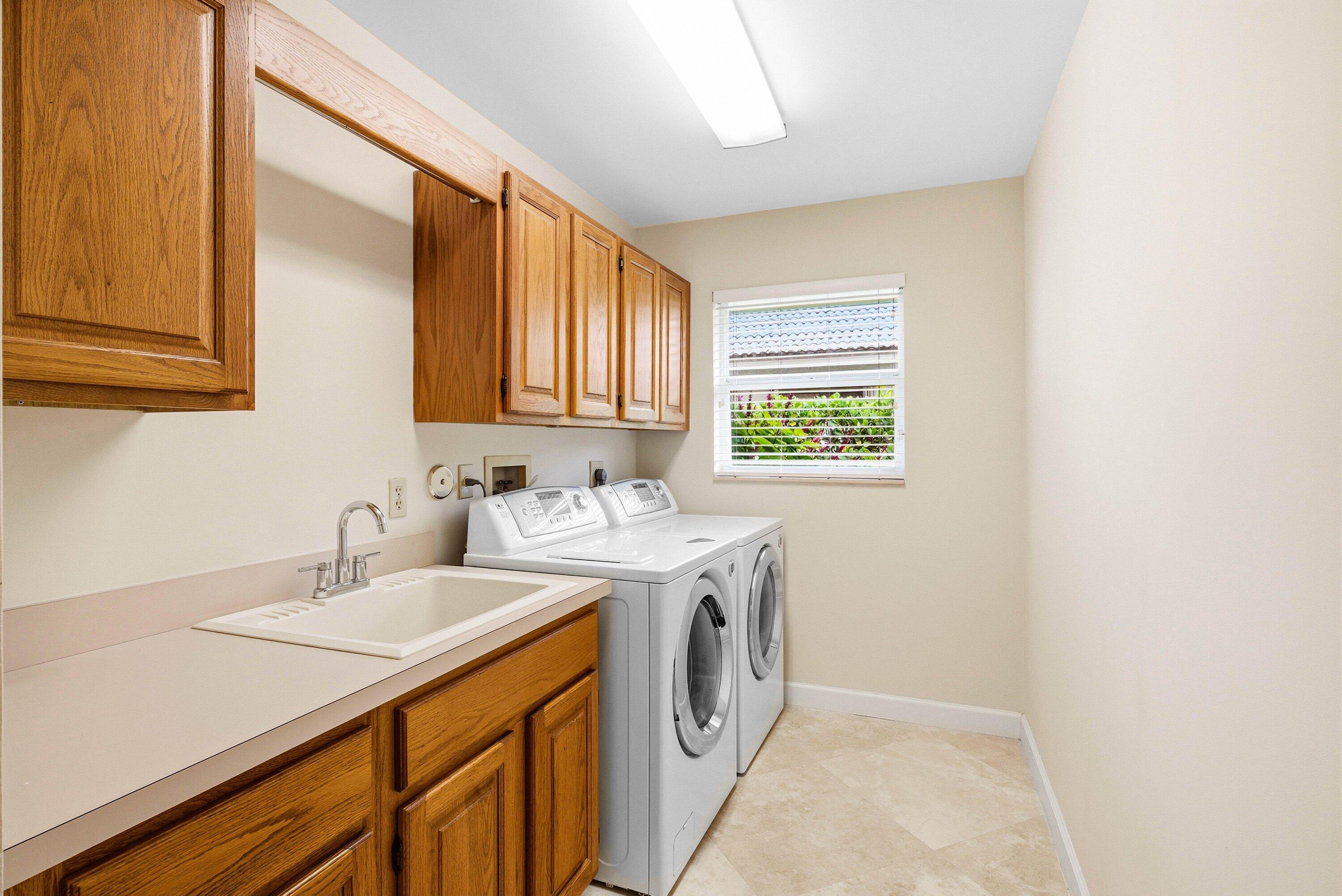 4720 Northwest 28th Avenue Boca Raton, FL 33434 - Photo 46 of 47 a utility room with cabinets washer and dryer