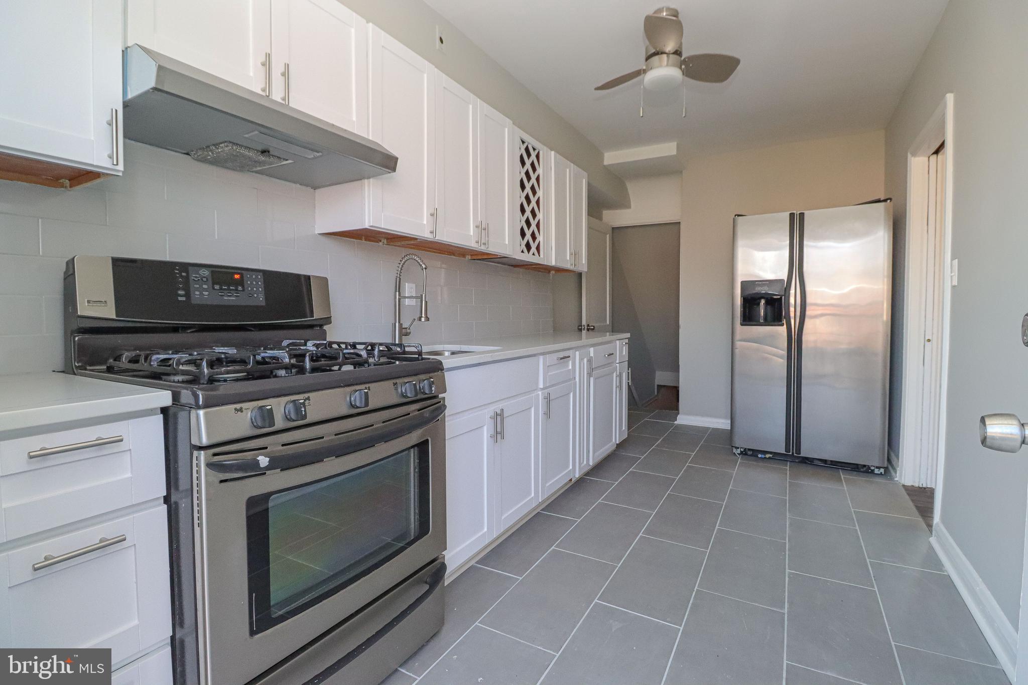 1260 Cedarcroft Road Baltimore, MD 21239 - Photo 13 of 30 a kitchen with stainless steel appliances a stove a microwave and cabinets