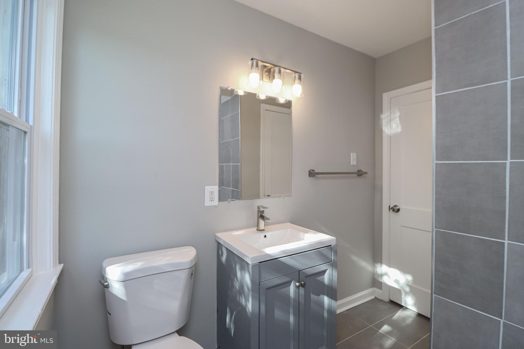 1260 Cedarcroft Road Baltimore, MD 21239 - Photo 16 of 30 a bathroom with a toilet sink and mirror