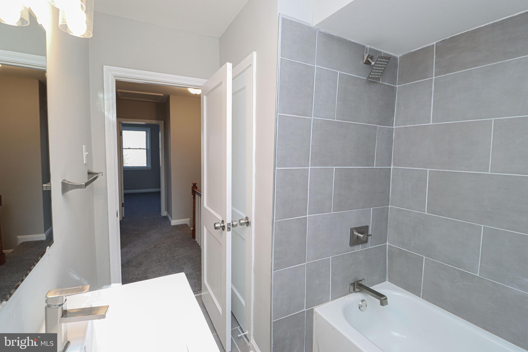 1260 Cedarcroft Road Baltimore, MD 21239 - Photo 17 of 30 a bathroom with a tub a sink and a mirror