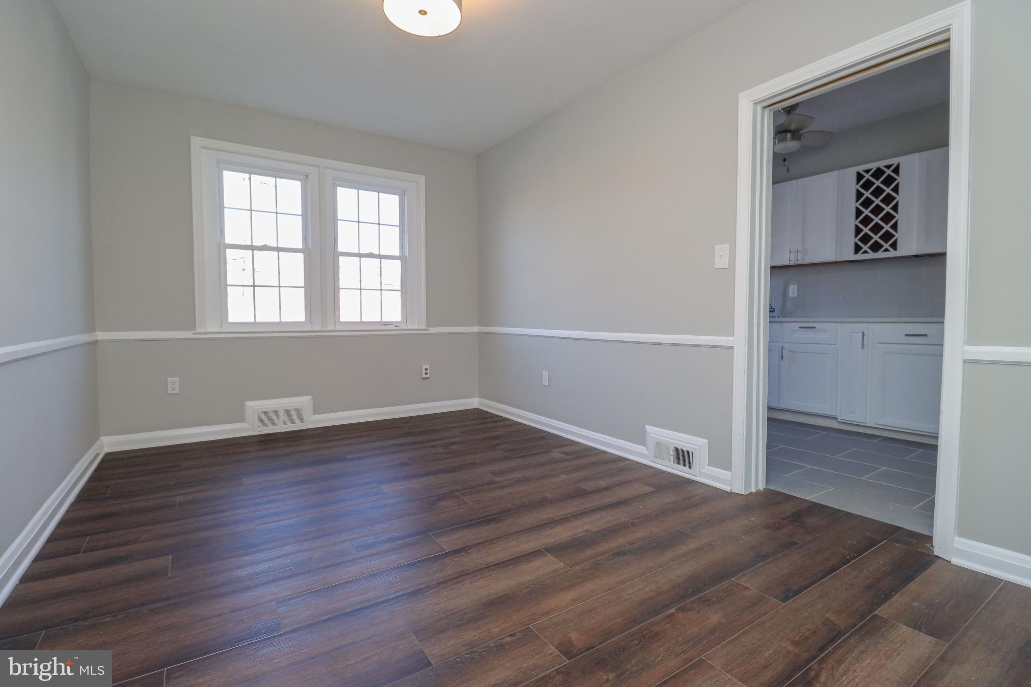 1260 Cedarcroft Road Baltimore, MD 21239 - Photo 6 of 30 an empty room with wooden floor and windows