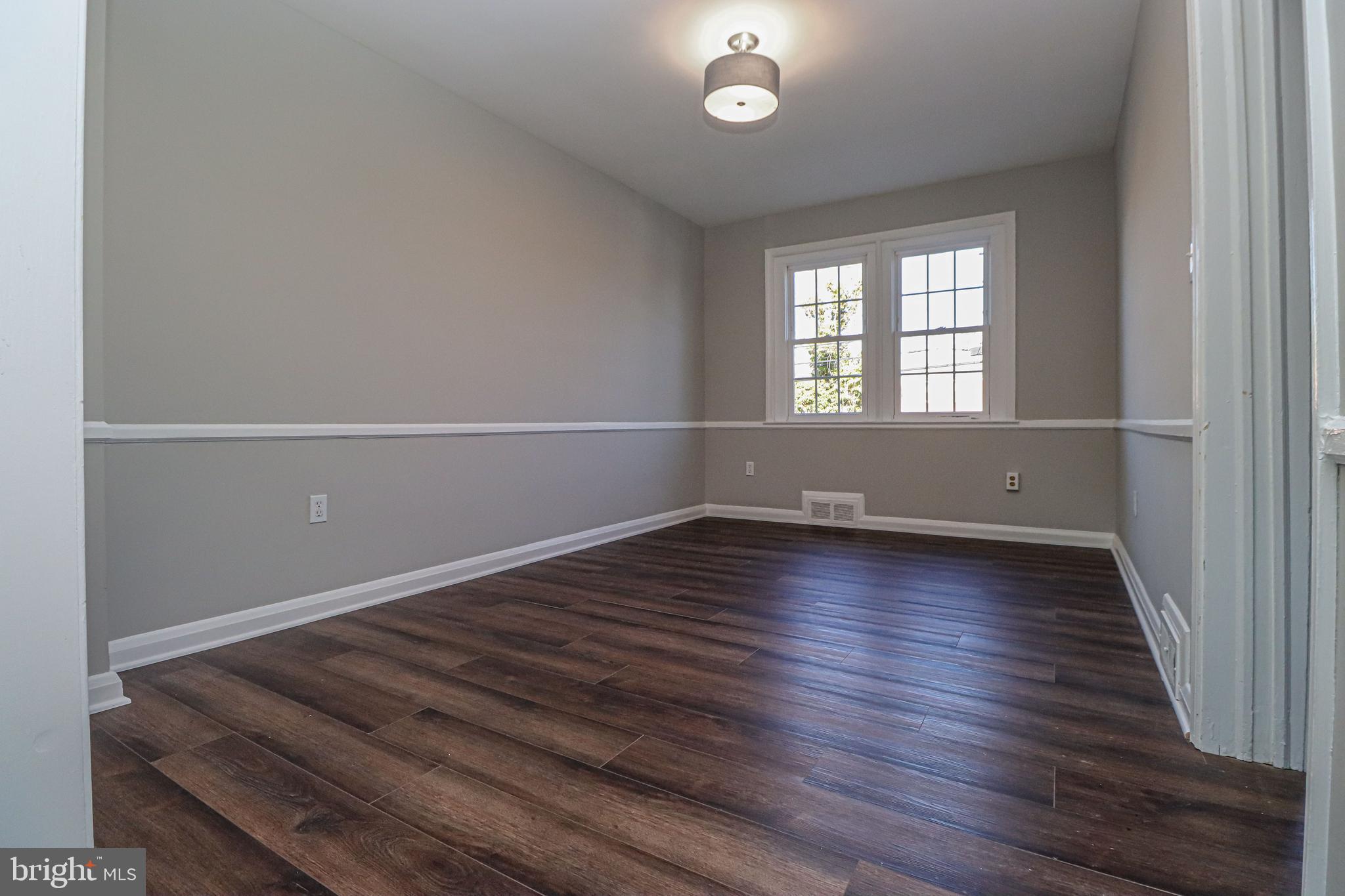 1260 Cedarcroft Road Baltimore, MD 21239 - Photo 7 of 30 an empty room with wooden floor and windows