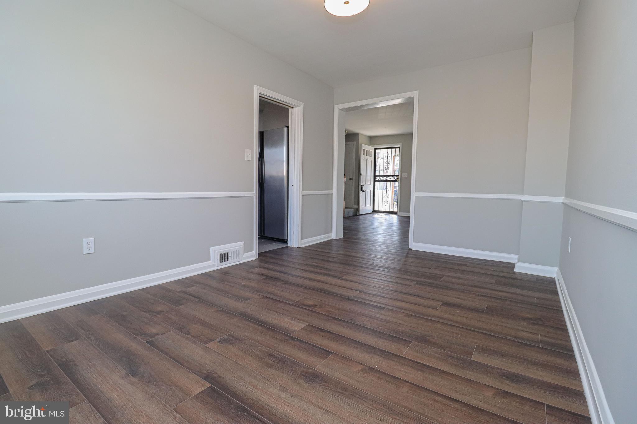 1260 Cedarcroft Road Baltimore, MD 21239 - Photo 8 of 30 a view of an empty room with wooden floor and a window