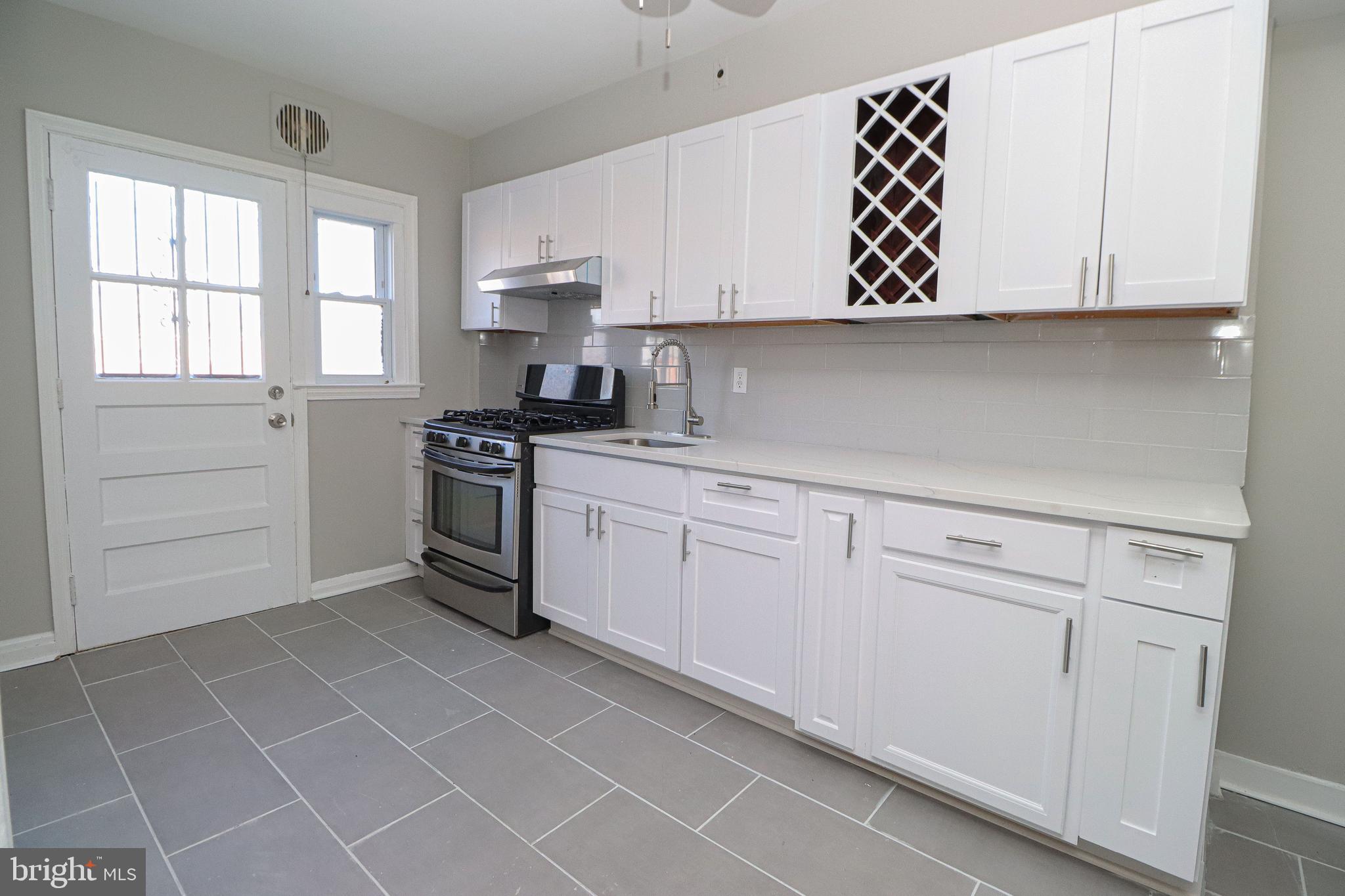 1260 Cedarcroft Road Baltimore, MD 21239 - Photo 9 of 30 a kitchen with white cabinets and white appliances