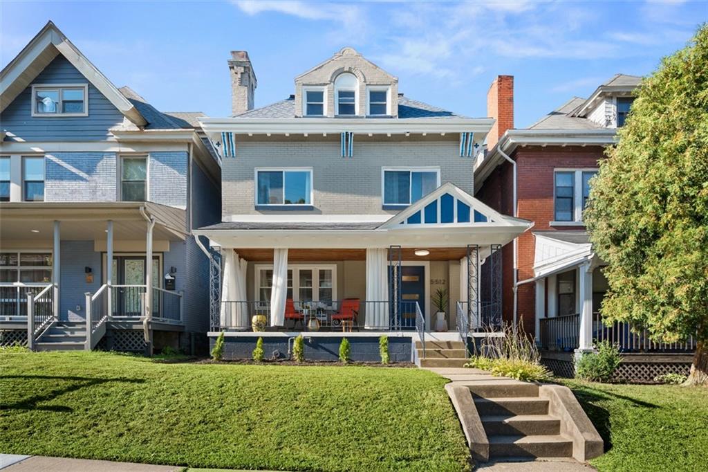 a view of white house with a big yard and large trees