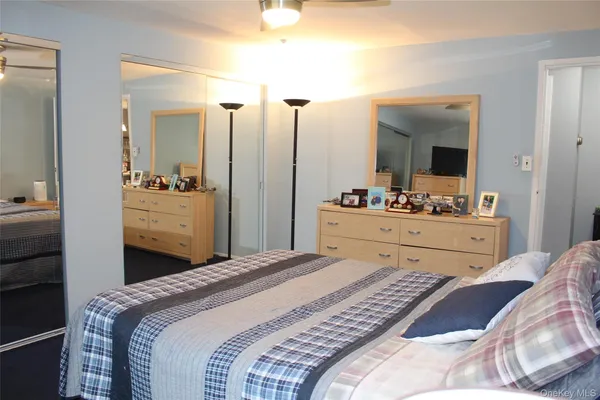 a bedroom with a bed and a large mirror