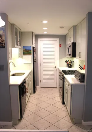 a kitchen with granite countertop a sink stove and refrigerator
