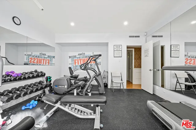 a large white kitchen with wooden floors and stainless steel appliances