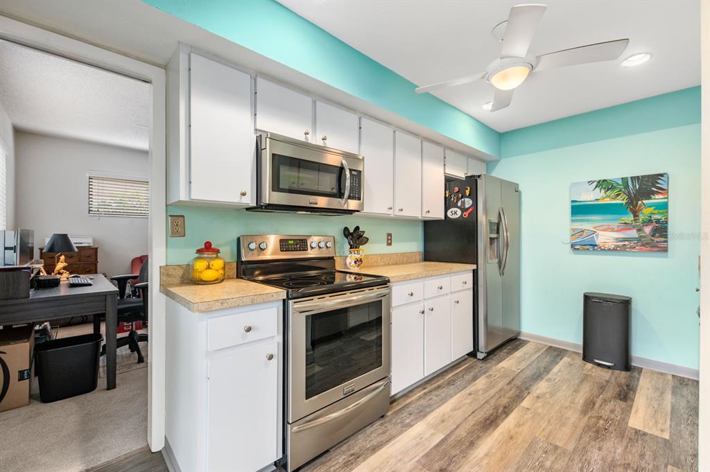 1701 Pelican Cove Road, Unit 359 Sarasota, FL 34231 - Photo 11 of 37 a kitchen with stainless steel appliances a stove sink microwave and cabinets