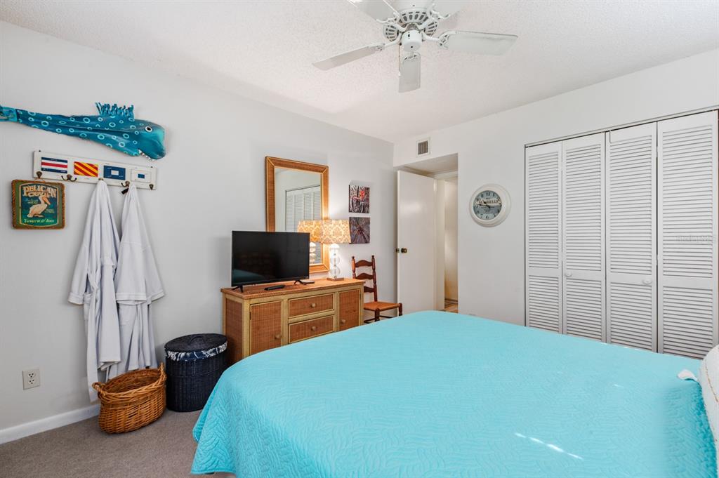 1701 Pelican Cove Road, Unit 359 Sarasota, FL 34231 - Photo 22 of 37 a bedroom with a bed and a flat tv screen on the dresser