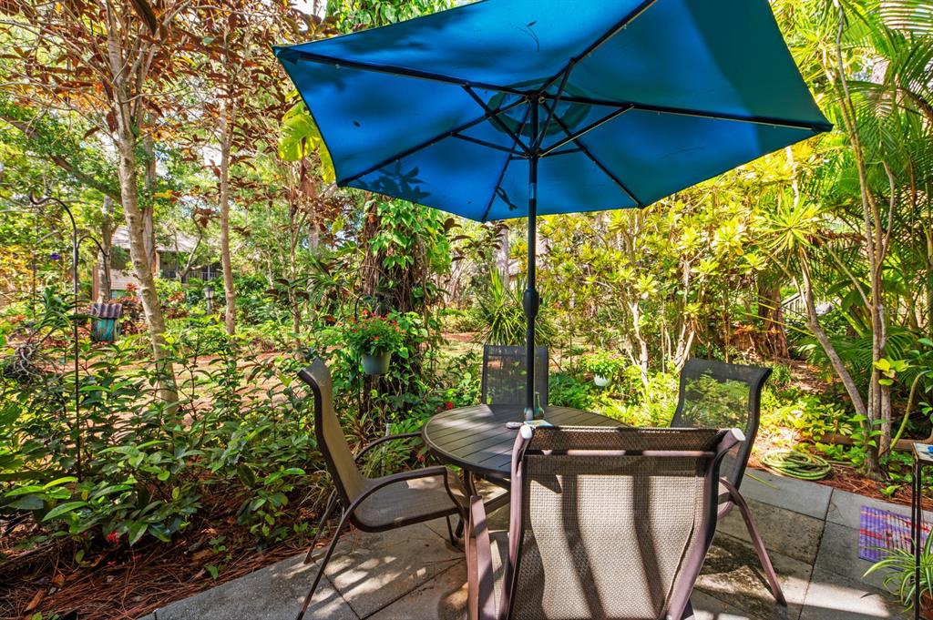 1701 Pelican Cove Road, Unit 359 Sarasota, FL 34231 - Photo 24 of 37 a view of an outdoor sitting area with furniture and umbrella