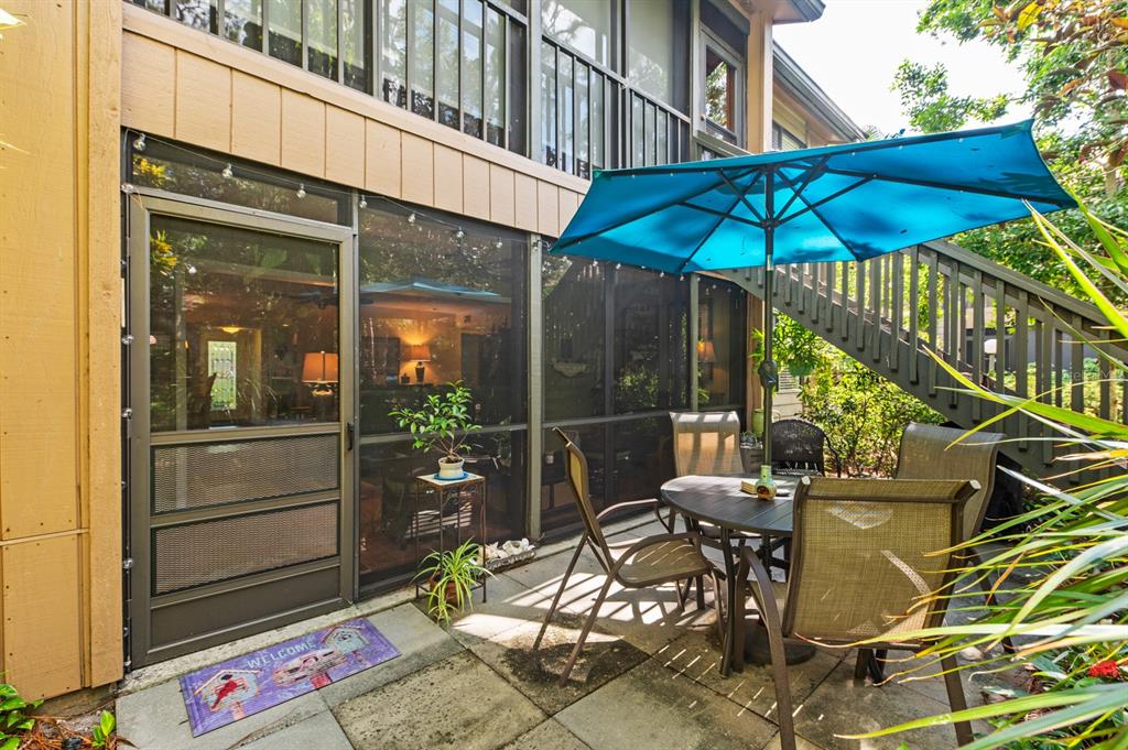 1701 Pelican Cove Road, Unit 359 Sarasota, FL 34231 - Photo 25 of 37 a view of a patio with table and chairs under an umbrella