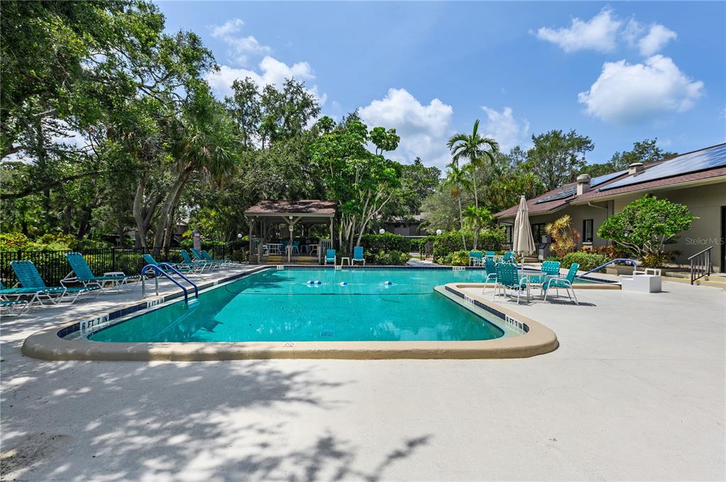 1701 Pelican Cove Road, Unit 359 Sarasota, FL 34231 - Photo 28 of 37 a view of a swimming pool with a patio and plants