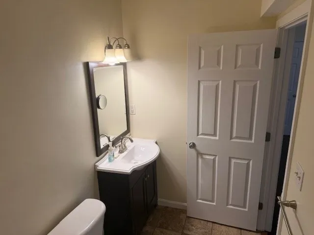 a bathroom with a sink vanity mirror and toilet