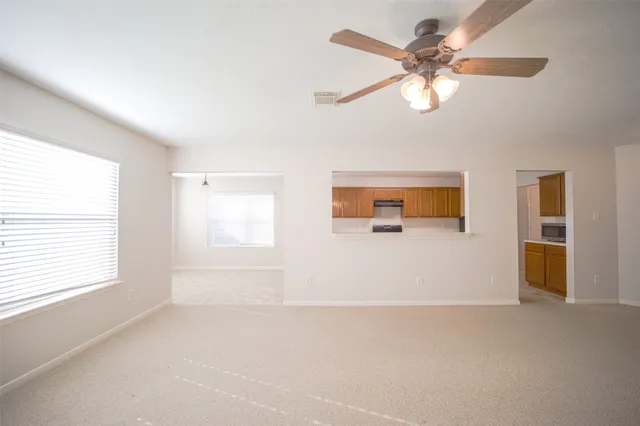 an empty room with windows and fan
