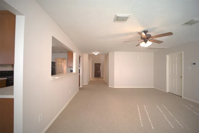 a view of an empty room with a ceiling fan