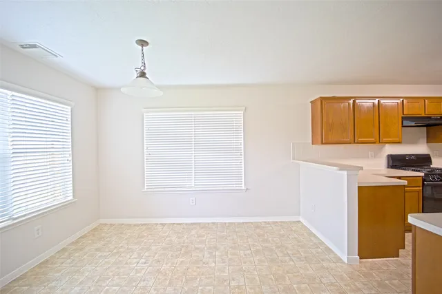 a view of a kitchen with wooden floor and electronic appliances