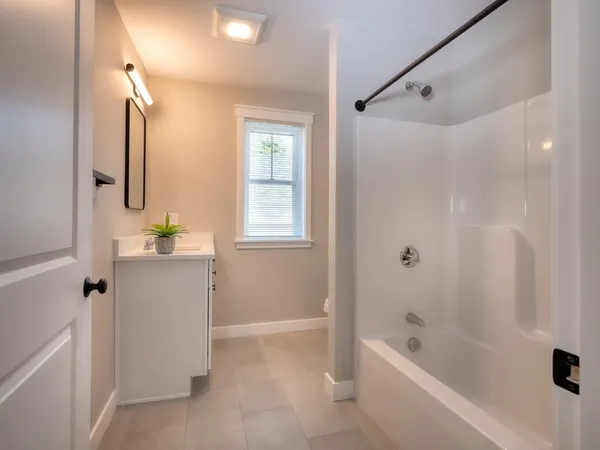 a bathroom with a bathtub sink and mirror