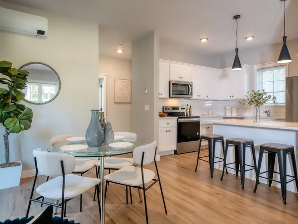 a kitchen with granite countertop a table chairs stove and cabinets