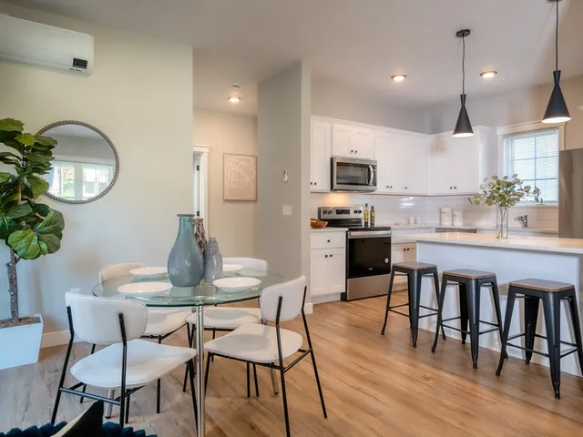 a kitchen with granite countertop a table chairs stove and cabinets