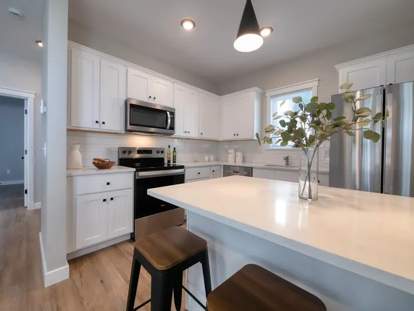 a kitchen with stainless steel appliances white cabinets a sink and a stove
