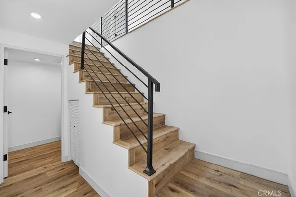 a view of a hallway with wooden floor and a window