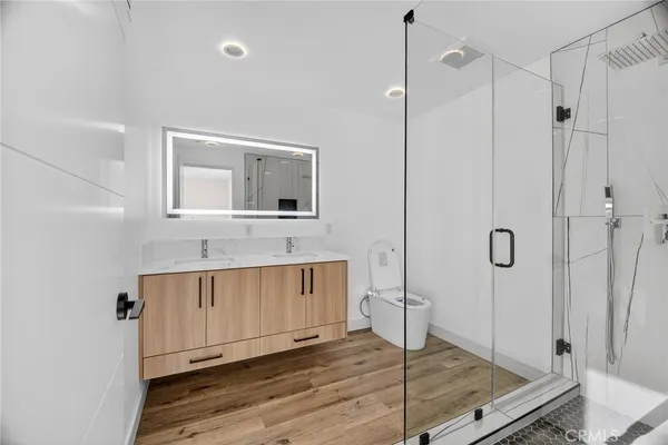 a bathroom with a granite countertop sink a mirror and shower