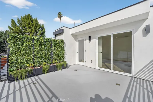 a balcony filled with a potted plant and outdoor seating
