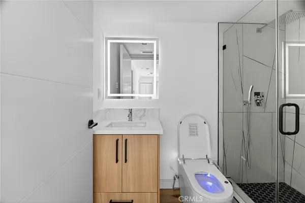 a bathroom with a toilet a sink a shower and mirror