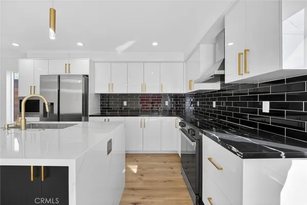 a kitchen with stainless steel appliances a sink stove and cabinets