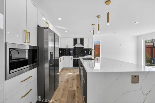 a kitchen with stainless steel appliances kitchen island granite countertop a refrigerator and a stove top oven