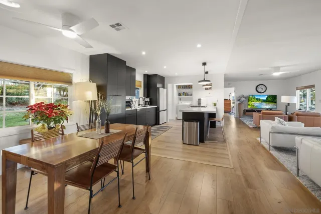 a kitchen with stainless steel appliances kitchen island granite countertop a dining table chairs and granite counter tops