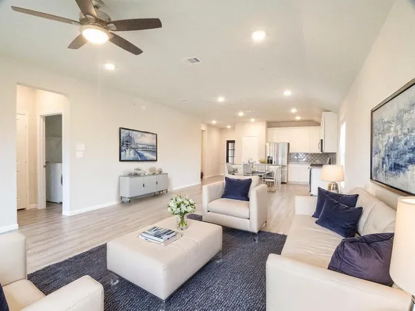 a living room with furniture and a view of kitchen