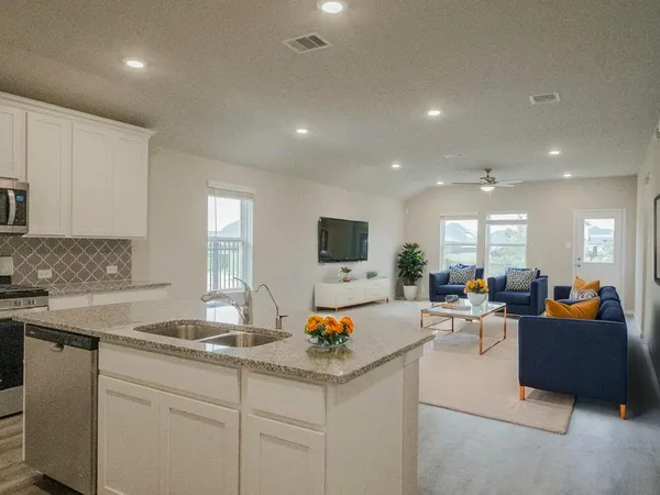 a living room with furniture kitchen view and a sink