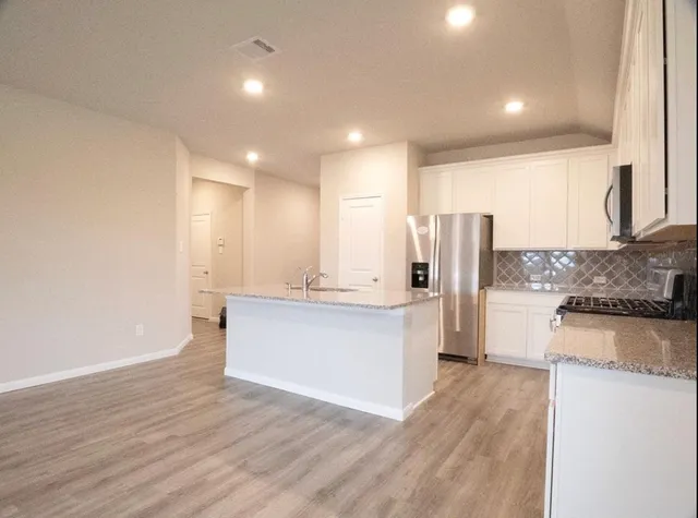 a large kitchen with a lot of counter space and stainless steel appliances