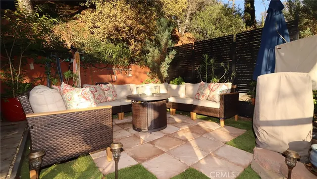 a view of a patio with table and chairs potted plants and large tree