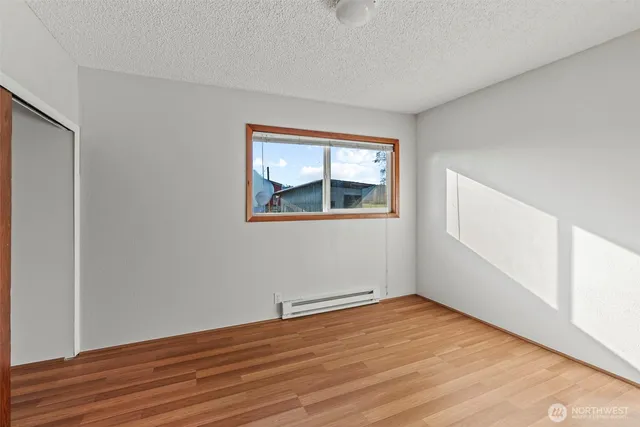 a view of a room with wooden floor and a window