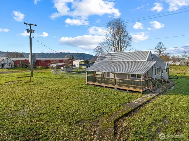 a view of a house with a big yard and a large tree