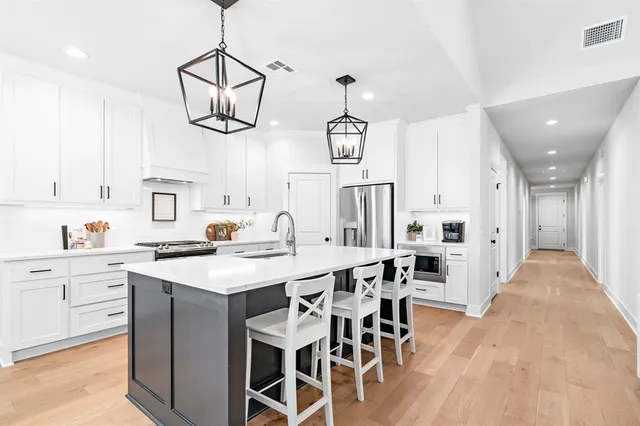 a kitchen with stainless steel appliances a table chairs and chandelier