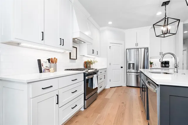 a kitchen with white cabinets and stainless steel appliances