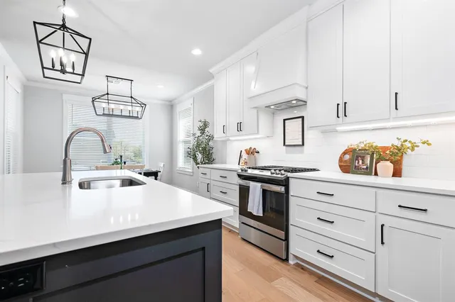 a kitchen with white cabinets and appliances