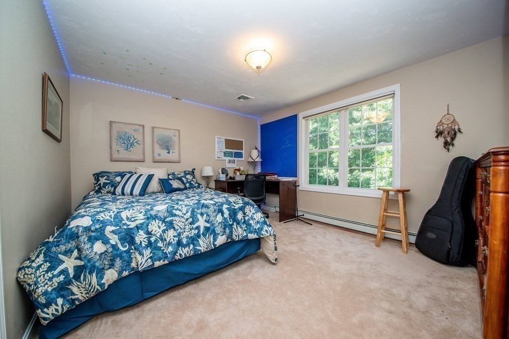 25 Squirrel Island Road Wareham, MA 02576 - Photo 29 of 39 a spacious bedroom with a bed and a chandelier