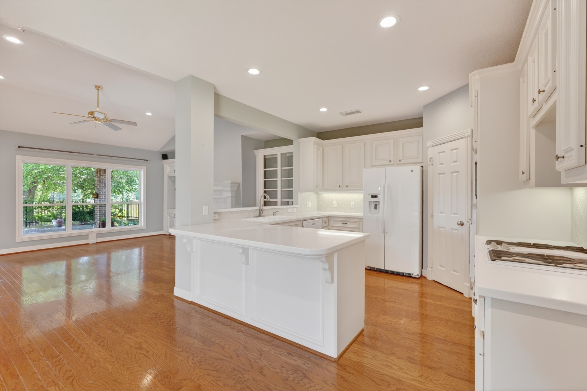 20714 Flora View Court Spring, TX 77379 - Photo 19 of 40 a large kitchen with stainless steel appliances granite countertop a refrigerator a sink and white cabinets with wooden floor