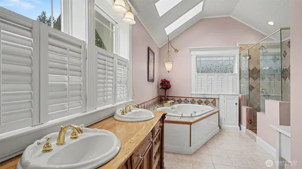 a bath room with a granite countertop tub sink and mirror
