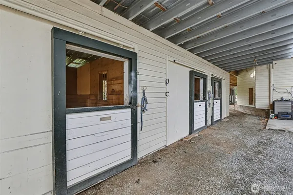 a view of a hallway with wooden fence and two windows