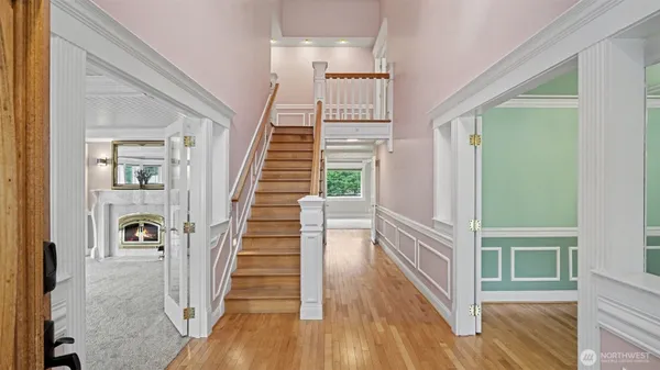 a view of a hallway with wooden floor and staircase