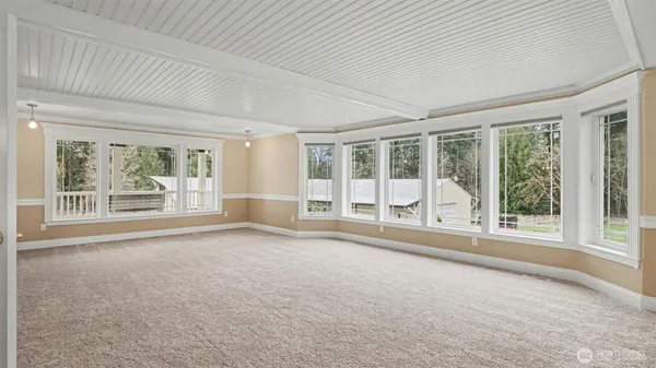 an empty room with wooden floor and floor to ceiling window