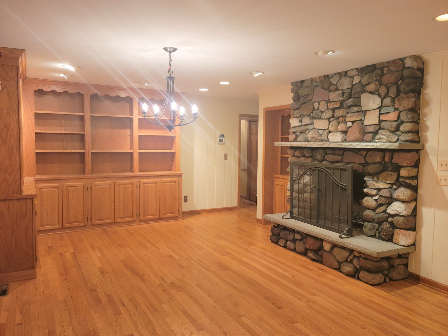 18715 Hebron Road Harvard, IL 60033 - Photo 12 of 54 an empty room with wooden floor and fireplace