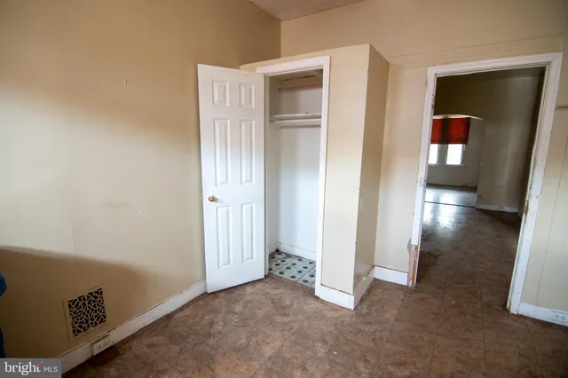 an empty room with wooden floor and closet